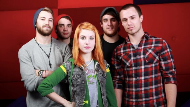 The Paramore band members pose together against a red background in this Paramore Wallpapers, HD Desktop Wallpaper