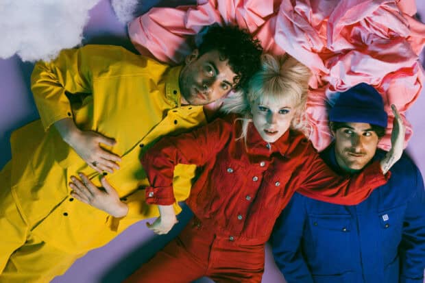Three members of Paramore are lying down wearing yellow, red, and blue clothes, HD Desktop Wallpaper