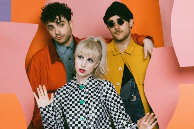 The members of Paramore are posing in colorful outfits against a vibrant background, HD Desktop Wallpaper