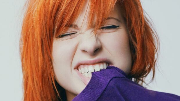 A close up of a person with bright red hair biting a purple sweater showcases Paramore wallpapers, HD Desktop Wallpaper