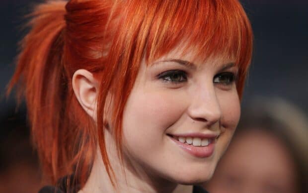 The image shows a close up of Paramore's lead singer with bright red hair and a smile, HD Desktop Wallpaper