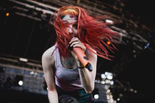 A Paramore singer passionately performs with vibrant red hair and dynamic stage presence, HD Desktop Wallpaper