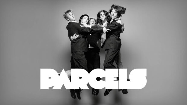 The Parcels band members jump together in a black and white studio photo, 2K Desktop Wallpaper