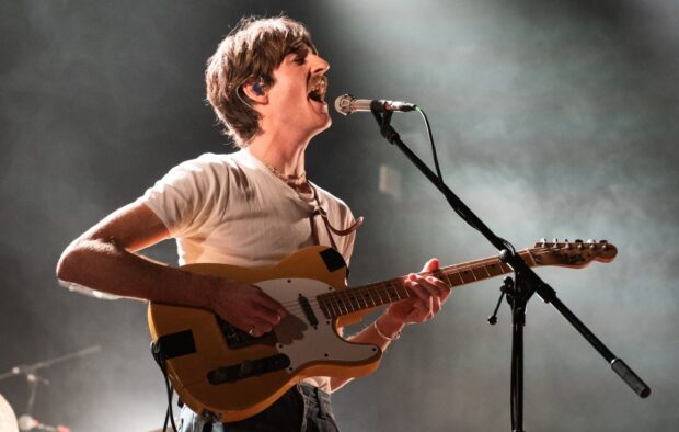 A Parcels Band member passionately sings and plays guitar on stage, HD Desktop Wallpaper