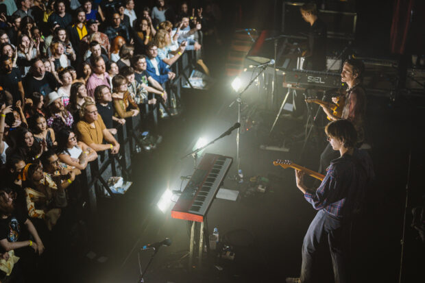 The Parcels Band is playing instruments during a concert with an engaged audience, HD Desktop Wallpaper
