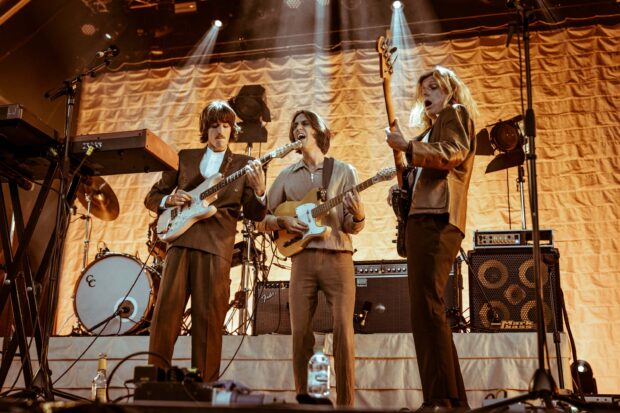 The Parcels band is playing guitars and singing during a live concert, 2K Desktop Wallpaper