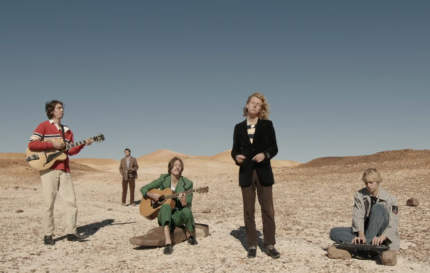 The Parcels band is performing instruments in a desert landscape under clear skies, HD Desktop Wallpaper
