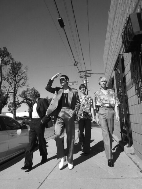 The Parcels band is walking down a sidewalk with power lines and street signs visible above, 2K Desktop Wallpaper