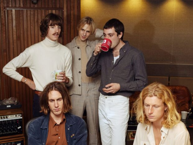 The Parcels band members are gathered inside a room with wooden panels drinking from mugs, 2K Desktop Wallpaper