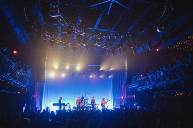The Parcels band is playing music in front of a large audience at a concert venue, HD Desktop Wallpaper