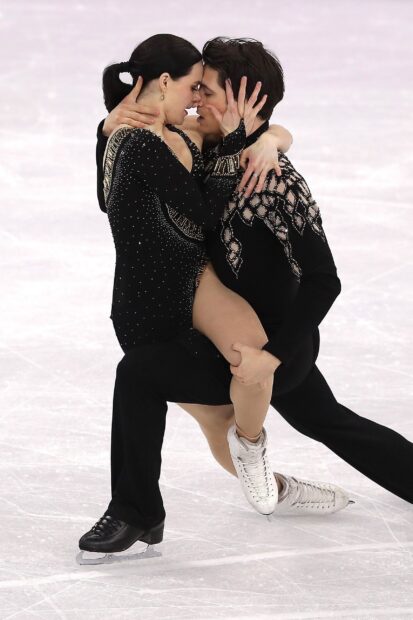 A passionate ice dancing couple is performing an elegant routine on the ice rink, 2K Mobile Wallpaper
