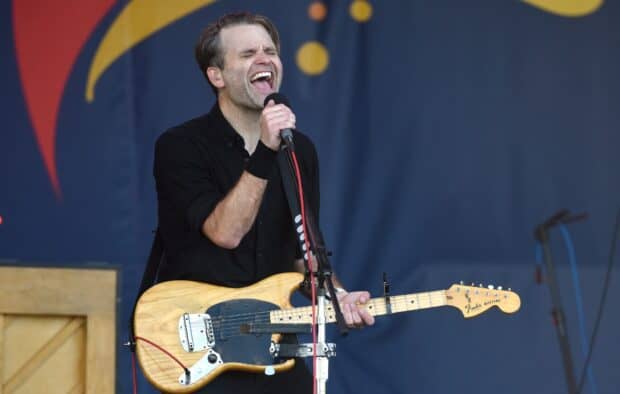 A member of Death Cab For Cutie singing and playing guitar on stage at a live concert, HD Desktop Wallpaper