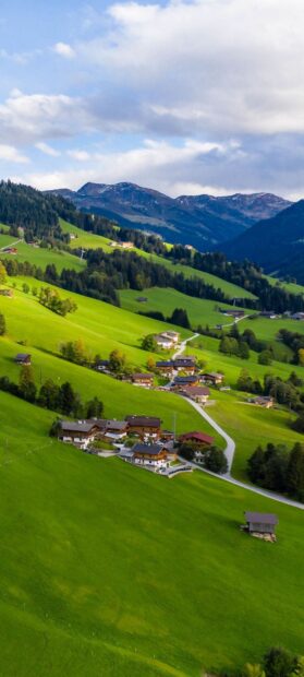 A peaceful village is nestled among vibrant green hills under a cloudy sky in these village wallpapers, HD Phone Wallpaper