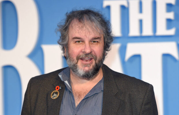 Peter Jackson smiles wearing a lapel pin on a blue background, 2K Desktop Wallpaper