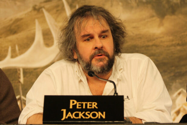 Peter Jackson speaking at a conference with a microphone in front of him, HD Desktop Wallpaper