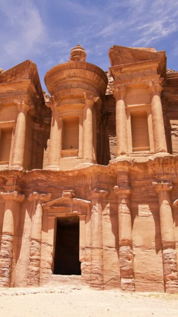 The image shows the famous ancient rock cut architecture in Petra Jordan under a clear blue sky, HD Phone Wallpaper