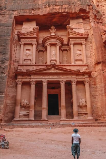 A person stands in front of the ancient rock carved facade of Petra Jordan Wallpapers, HD Mobile Wallpaper