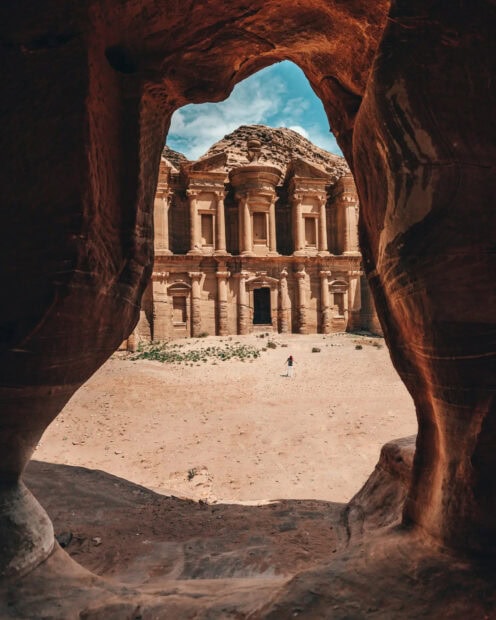 A person exploring Petra Jordan ancient site through the cave entrance, HD Mobile Wallpaper