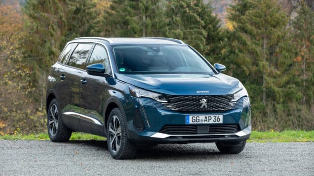 A blue Peugeot 5008 parked on a gravel road with trees in the background, 4K PC Wallpaper