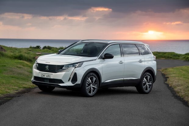 A white Peugeot 5008 stands on a road near the coastline during sunset, 2K Desktop Wallpaper