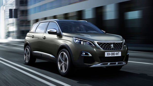 A Peugeot 5008 drives fast along a blurred urban road with modern buildings in the background, 4K Desktop Wallpaper