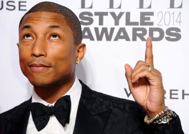 Pharrell Williams in a black patterned tuxedo pointing upward at an event, 2K Desktop Wallpaper