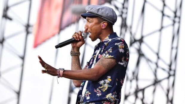 Pharrell Williams is singing into a microphone during a concert, HD Desktop Wallpaper