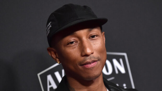 Pharrell Williams is wearing a black cap and smiling gently, 2K Desktop Wallpaper