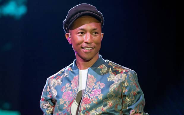 Pharrell Williams is smiling and wearing a floral jacket during a live performance, 2K Desktop Wallpaper