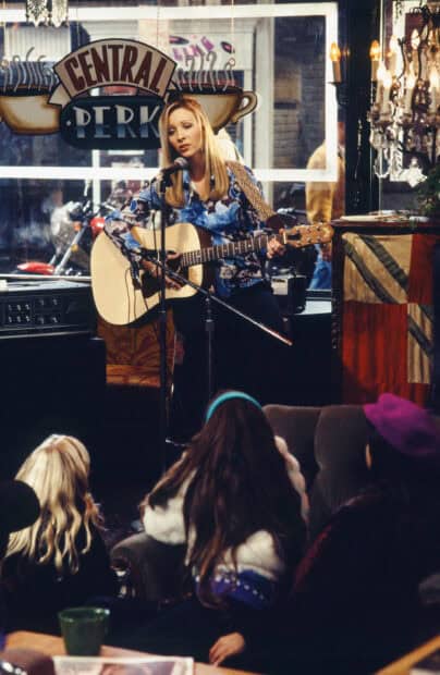 Phoebe Buffay is performing with her guitar at Central Perk, 2K Portrait Wallpaper