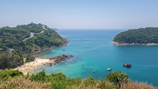 A clear turquoise sea encloses the green Phuket coastline with boats and a sandy beach, HD Desktop Wallpaper