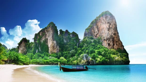 A traditional boat floating near rocky cliffs in Phuket wallpapers, 4K Desktop Wallpaper