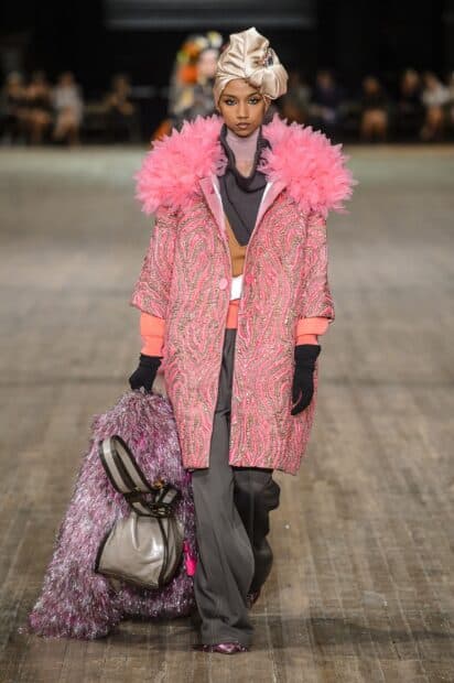 A model wears a pink textured coat and carries a large shiny bag in the Marc Jacobs fashion show, 2K Desktop Wallpaper