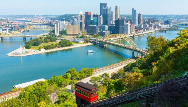 A vibrant view of Pittsburgh skyline featuring the river bridges and cityscape under clear skies, HD Desktop Wallpaper