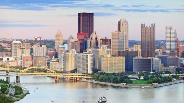 The Pittsburgh skyline features iconic buildings along the river during sunset, HD Desktop Wallpaper