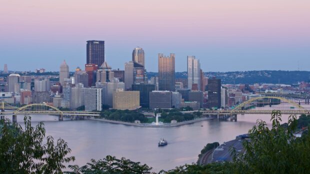 The Pittsburgh skyline displays skyscrapers and rivers under a pastel sky, HD Desktop Wallpaper