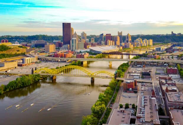 The Pittsburgh skyline features yellow bridges over the river under a bright sky, HD Desktop Wallpaper
