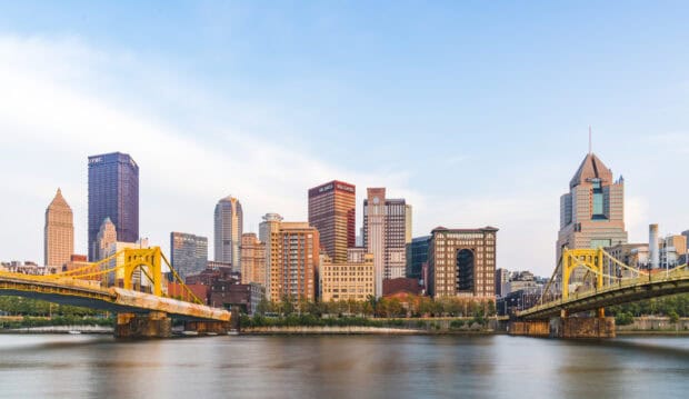 The Pittsburgh skyline features iconic yellow bridges along the river with tall city buildings in the background, HD Desktop Wallpaper