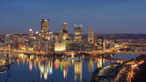 The Pittsburgh skyline features illuminated buildings reflecting on the river at dusk, HD Desktop Wallpaper