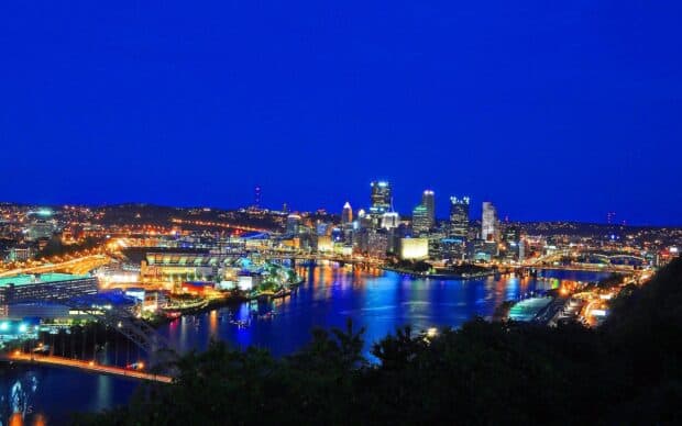 The Pittsburgh skyline shows bright city lights reflecting on the river at night, HD Desktop Wallpaper