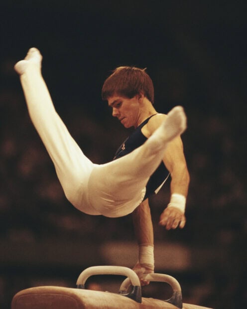 A gymnast performs a routine on the pommel horse with focused concentration, HD Mobile Wallpaper