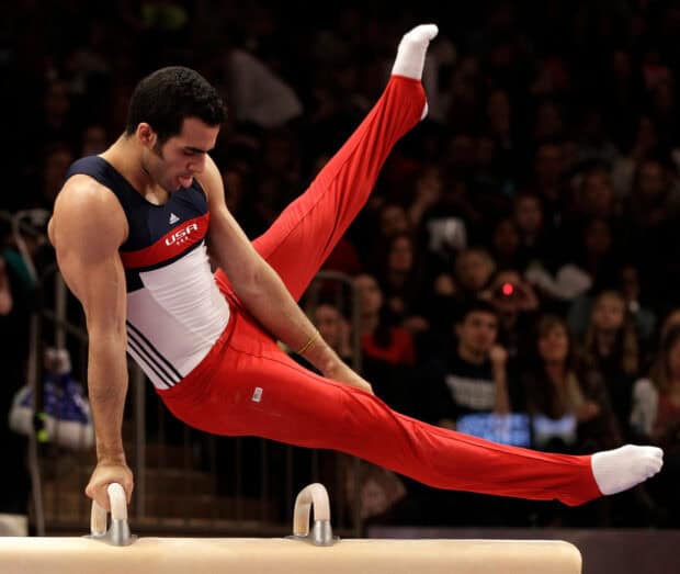 A male gymnast performs a pommel horse routine during a competition, HD Desktop Wallpaper