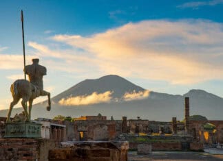 The Pompeii Wallpapers show ancient ruins with Mount Vesuvius rising in the background under a cloudy sky, HD Desktop Wallpaper