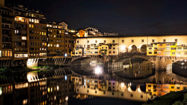 The Ponte Vecchio at night reflects beautifully on the calm river with warm lights, HD Desktop Wallpaper