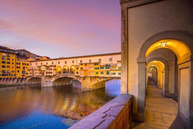 The Ponte Vecchio shows historic buildings over the Arno River during sunset, 2K Desktop Wallpaper