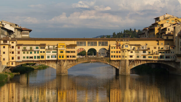Italy, Ponte Vecchio bridge reflecting on the Arno river in Florence under cloudy sky, HD Desktop Wallpaper