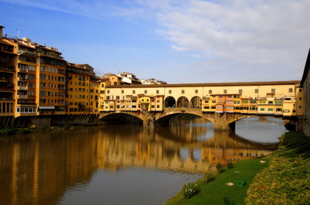 The historic Ponte Vecchio spans the Arno river with buildings lining the bridge in Florence, Italy, HD Desktop Wallpaper