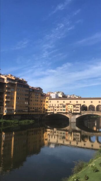 The Ponte Vecchio bridge reflects beautifully on the Arno River under a clear blue sky, HD Phone Wallpaper