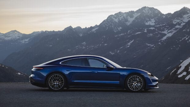 A blue Porsche Taycan is parked with a scenic mountain range in the background, HD Desktop Wallpaper