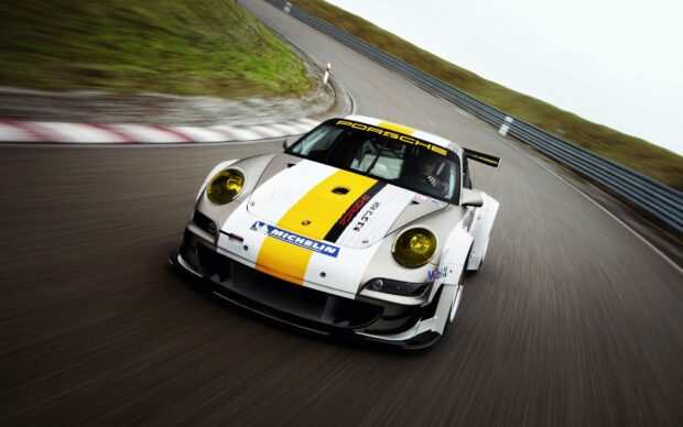 A Porsche race car speeds along a curved race track in a competitive race setting, 2K Desktop Wallpaper